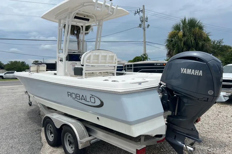 Slide: The Image of 2024 Robalo 226 Cayman boat with Yamaha engine on trailer, parked outdoors. - 2