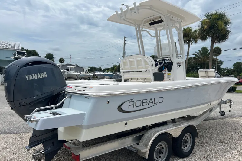 Slide: The Image of 2024 Robalo 226 Cayman boat with Yamaha engine on trailer, parked outdoors. - 4