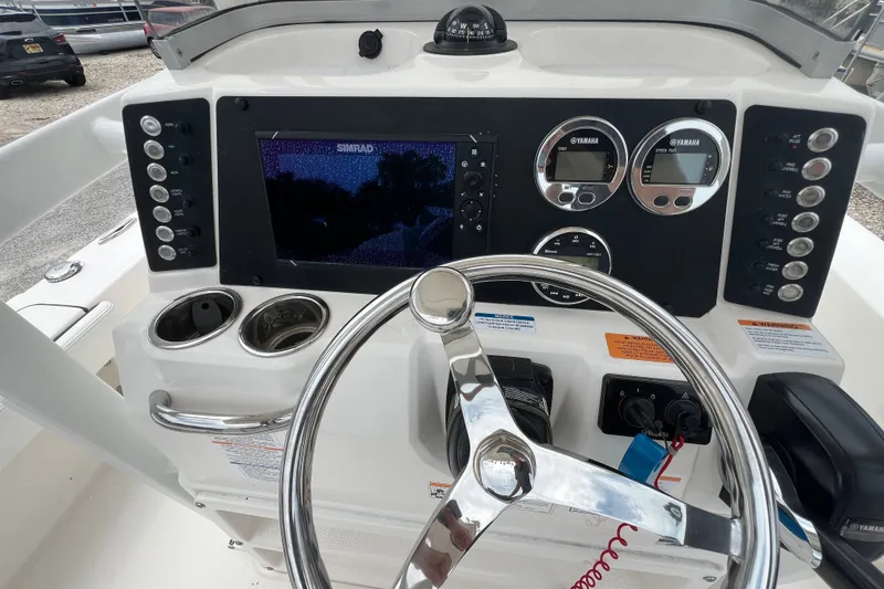Slide: The Image of 2024 Robalo 226 Cayman boat dashboard with steering wheel and electronic controls. - 11