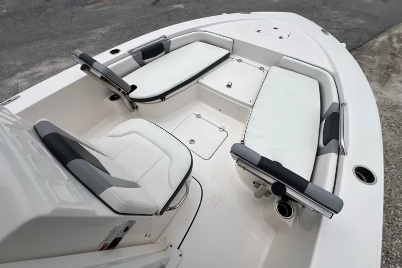 Slide: The Image of 2024 Robalo 226 Cayman boat interior with cushioned seating and storage compartments. - 13