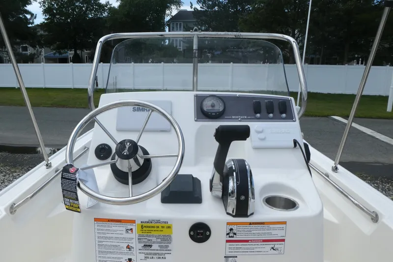 Slide: The Image of 2027 Boston Whaler 150 Montauk boat console with steering wheel and controls. - 8