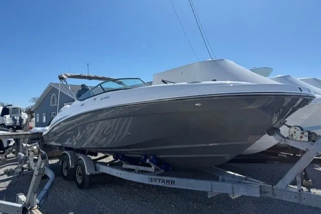 The Image of 2026 Hurricane SunDeck 2690 OB boat on trailer, parked outdoors under clear blue sky. - 0