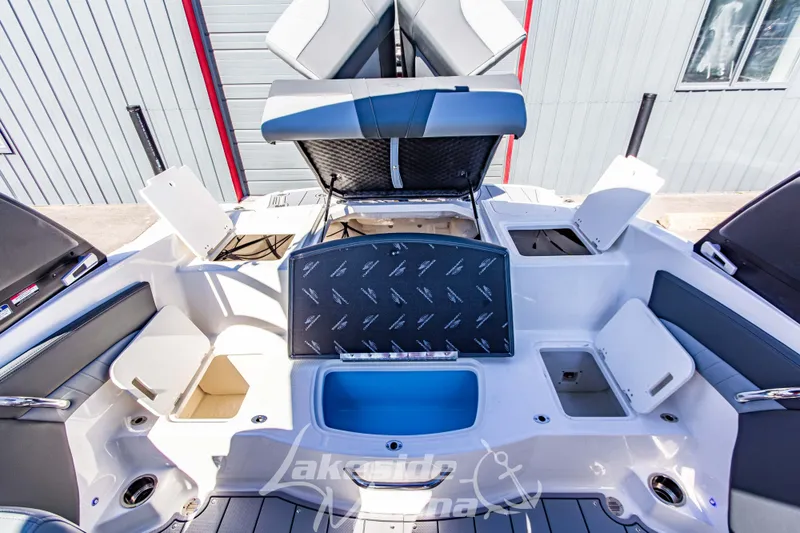Slide: The Image of 2026 Chaparral 21 SSi OB boat interior with open storage compartments and seating. - 18