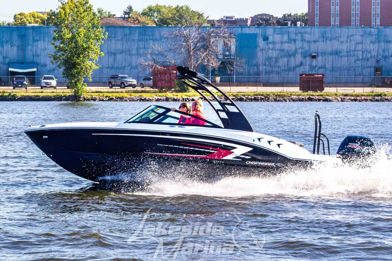 Slide: The Image of 2026 Chaparral 21 SSi OB boat cruising on a sunny day, creating waves. - 2