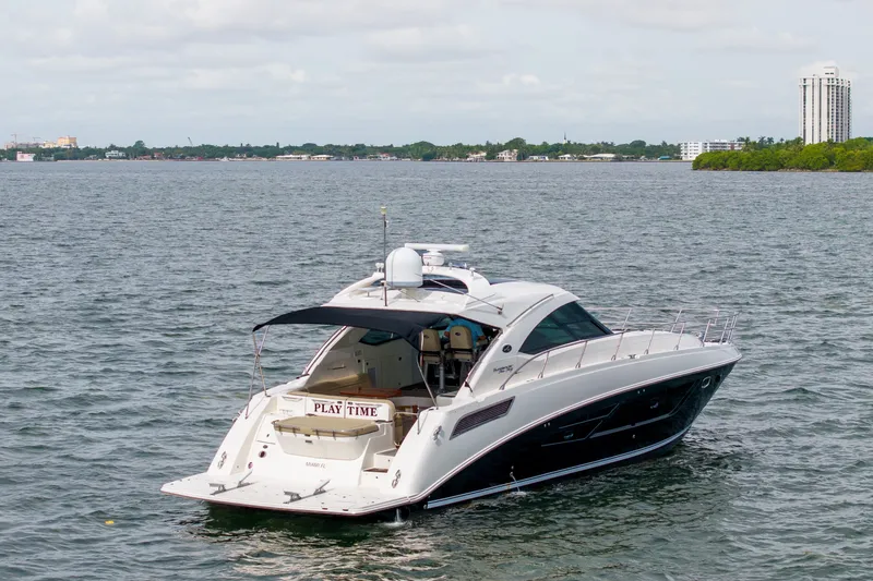 Slide: The Image of 2016 Sea Ray Sundancer 540 yacht on open water, with cityscape in the background. - 13