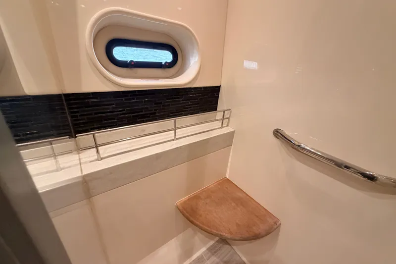 Slide: The Image of Luxurious bathroom interior of 2016 Sea Ray Sundancer 540 yacht with porthole and wooden seat. - 76