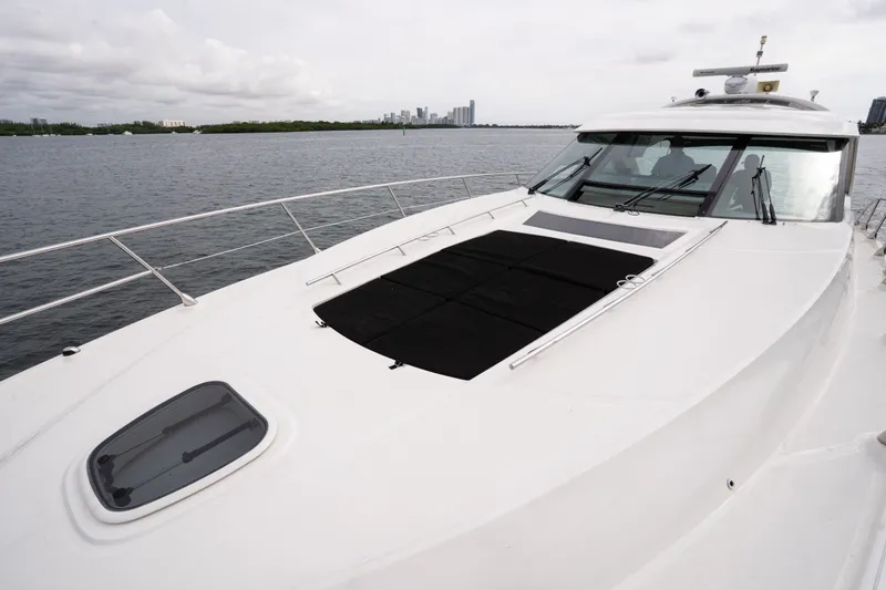 Slide: The Image of 2016 Sea Ray Sundancer 540 yacht on calm waters with city skyline in background. - 14