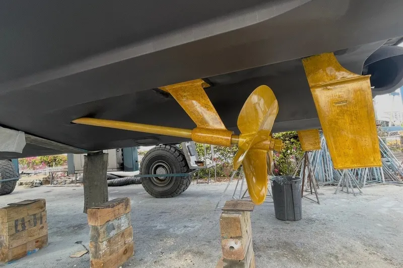 Slide: The Image of 2016 Sea Ray Sundancer 540 propeller and rudder detail, displayed on wooden blocks. - 102