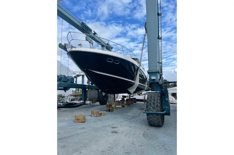 Slide: The Image of 2016 Sea Ray Sundancer 540 yacht lifted by crane, showcasing sleek design and luxury features. - 97