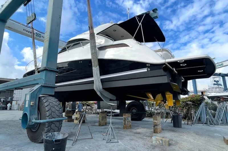 Slide: The Image of 2016 Sea Ray Sundancer 540 yacht in dry dock, undergoing maintenance under a clear blue sky. - 99