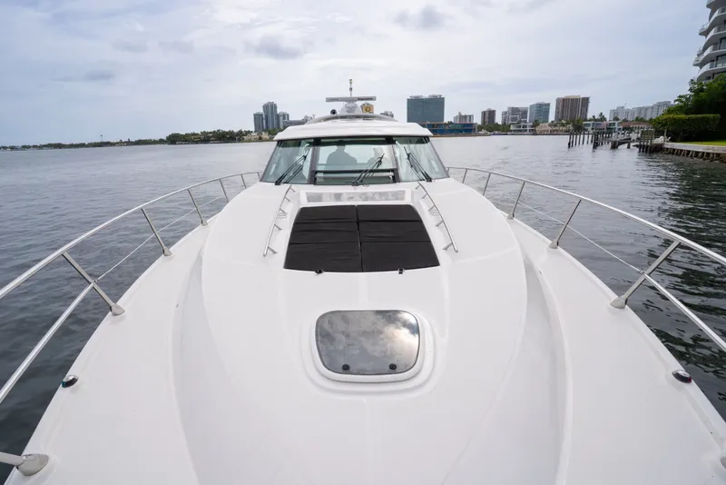 Slide: The Image of 2016 Sea Ray Sundancer 540 yacht on calm waters with city skyline in background. - 16