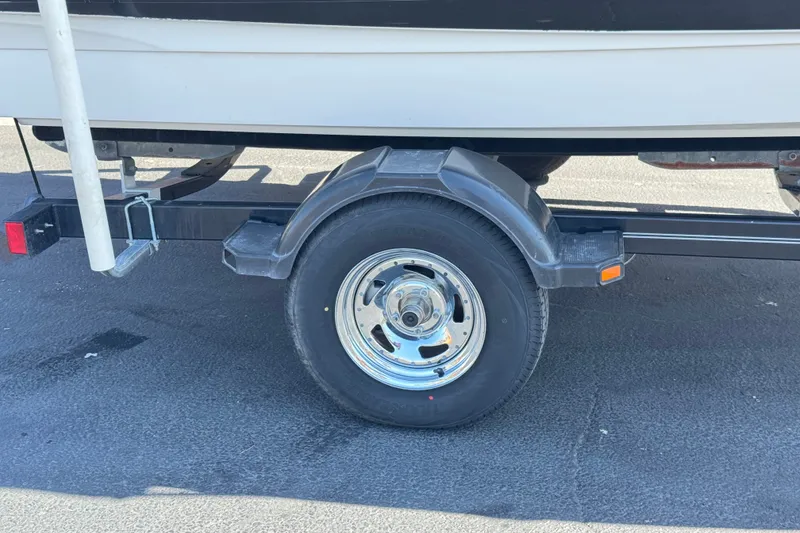 Slide: The Image of Trailer wheel of a 2011 Bayliner 185 Bowrider on asphalt pavement. - 24