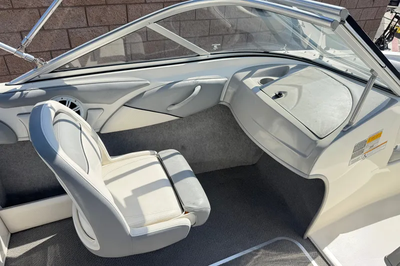 Slide: The Image of 2011 Bayliner 185 Bowrider interior with white seating and dashboard. - 18
