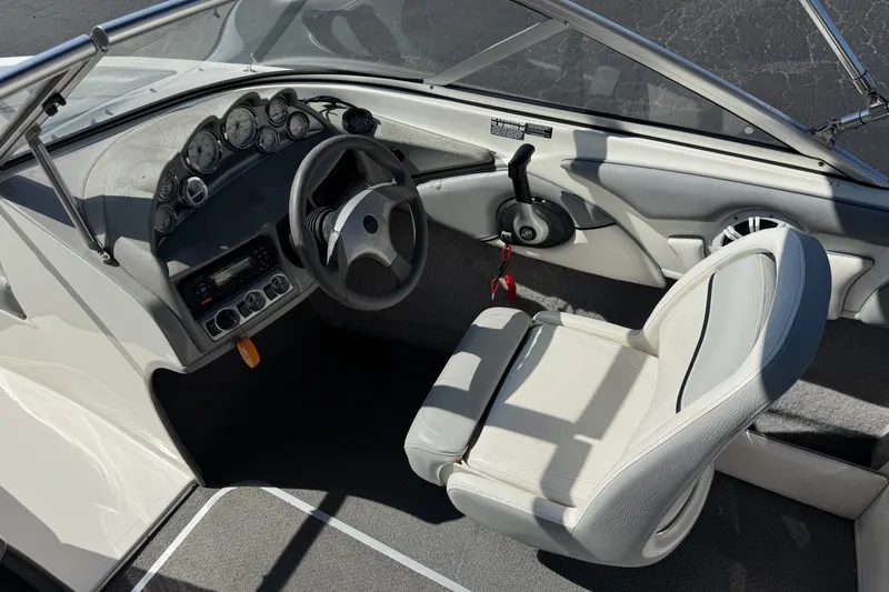 Slide: The Image of 2011 Bayliner 185 Bowrider cockpit with steering wheel, gauges, and white seating. - 21
