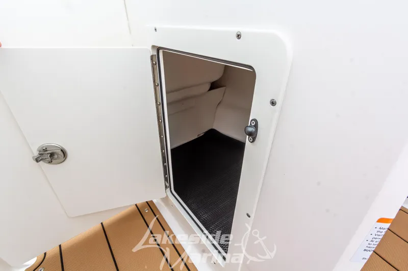 Slide: The Image of 2025 Chaparral 21 SSi boat storage compartment with open door. - 32