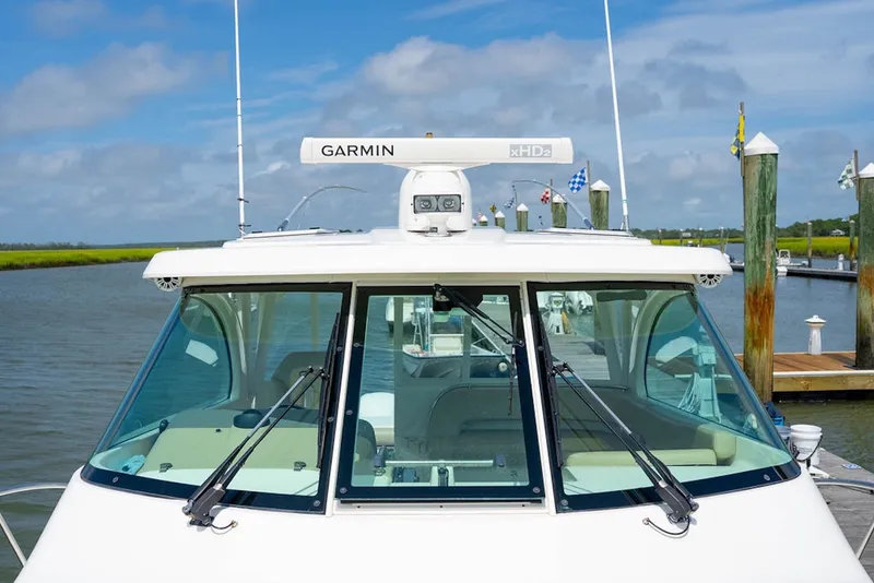 Slide: The Image of 2015 Pursuit OS 385 Offshore boat docked, featuring Garmin radar system. - 21