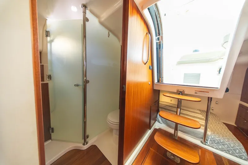 Slide: The Image of Interior of 2015 Pursuit OS 385 Offshore boat, featuring a modern bathroom and wooden steps. - 30