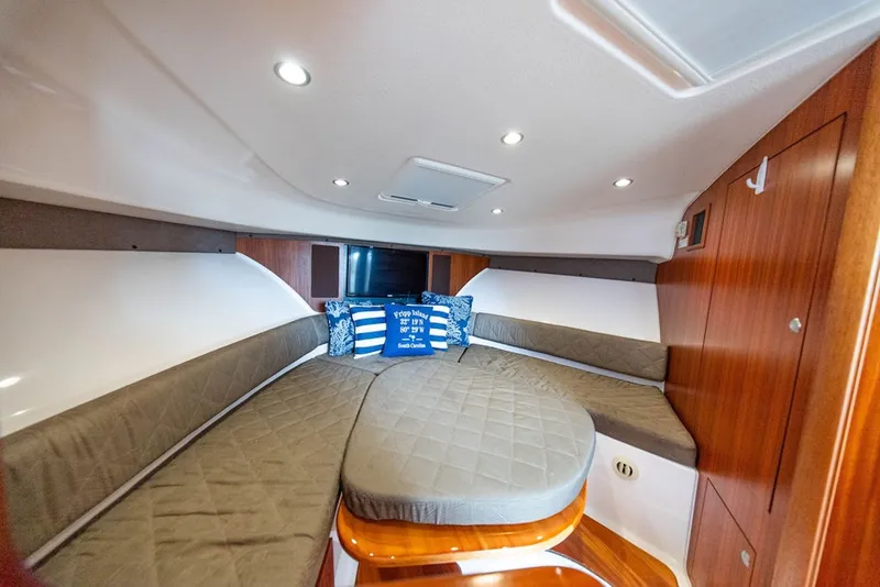 Slide: The Image of 2015 Pursuit OS 385 Offshore cabin interior with cozy seating and nautical decor. - 28