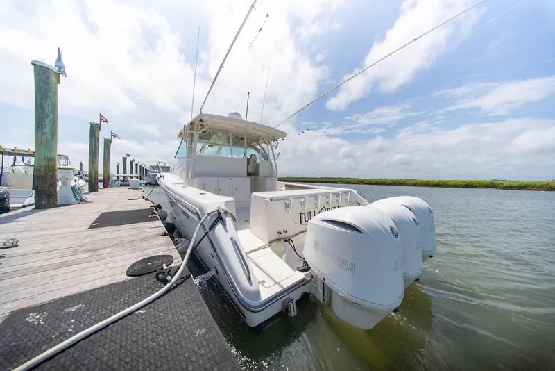 Slide: The Image of 2015 Pursuit OS 385 Offshore boat docked with triple Yamaha engines. - 5
