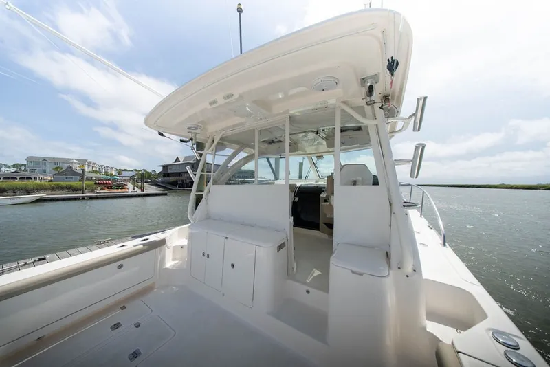 Slide: The Image of 2015 Pursuit OS 385 Offshore boat docked, showcasing spacious deck and seating area. - 13