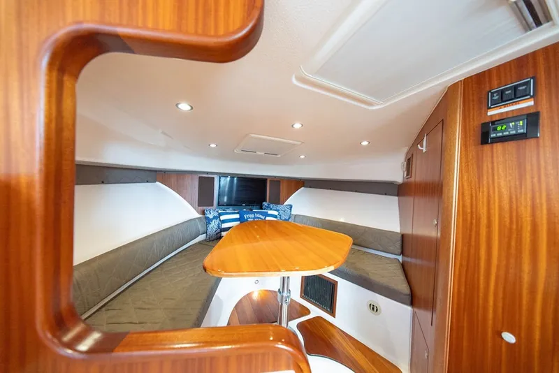 Slide: The Image of Interior of 2015 Pursuit OS 385 Offshore boat with wood finish and cozy seating area. - 26