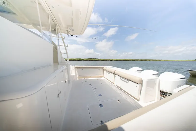 Slide: The Image of 2015 Pursuit OS 385 Offshore boat deck with seating, overlooking serene water. - 12