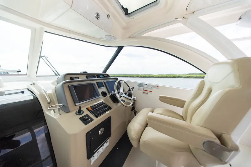 Slide: The Image of Interior cockpit of 2015 Pursuit OS 385 Offshore boat with steering wheel and controls. - 18
