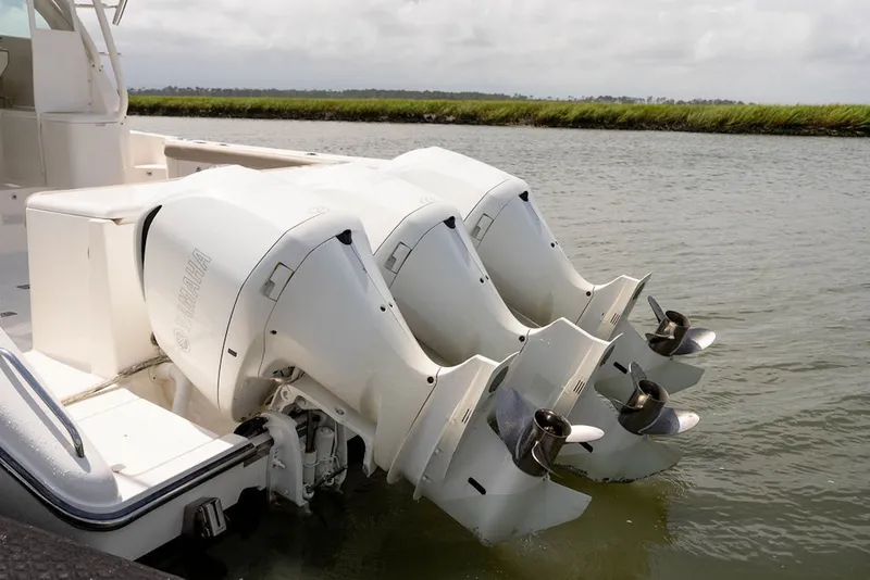 Slide: The Image of Triple Yamaha outboard engines on a 2015 Pursuit OS 385 Offshore boat in calm waters. - 7