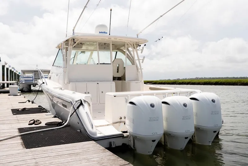 Slide: The Image of 2015 Pursuit OS 385 Offshore boat docked with triple outboard engines. - 4