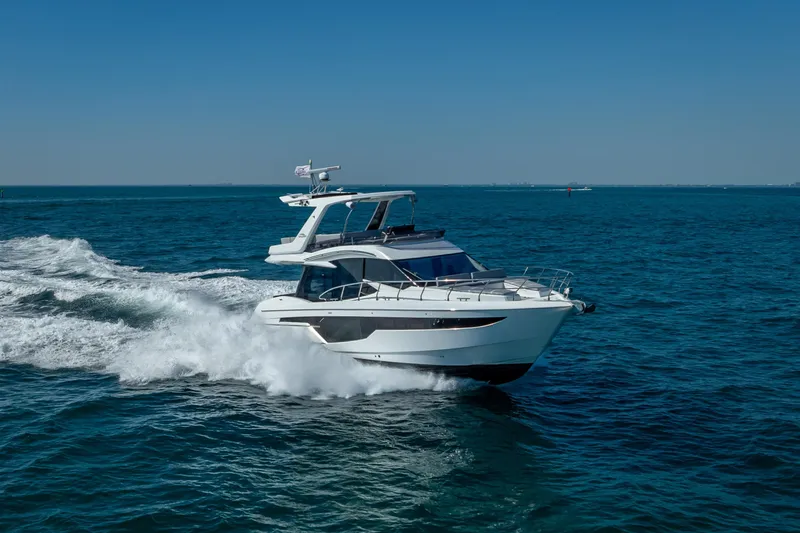 Slide: The Image of 2021 Galeon 500 Fly yacht cruising on open sea under clear blue sky. - 19
