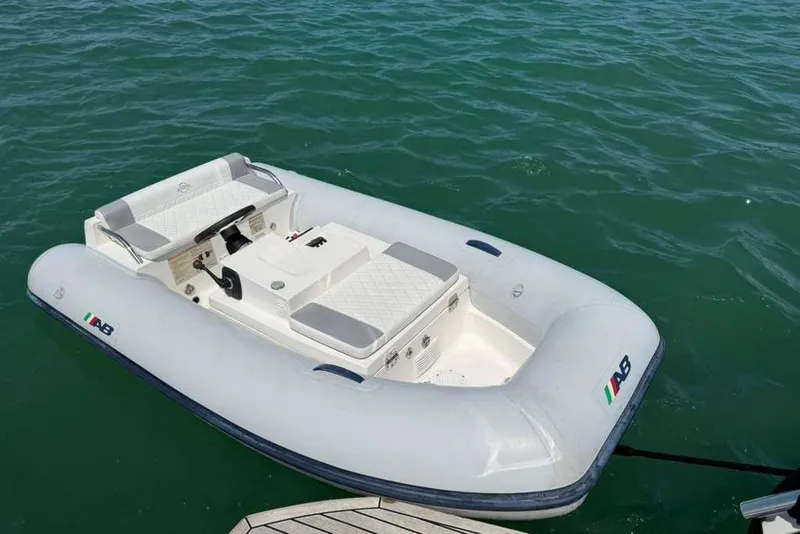 Slide: The Image of Inflatable boat on water, featuring AB logo, near dock. - 65