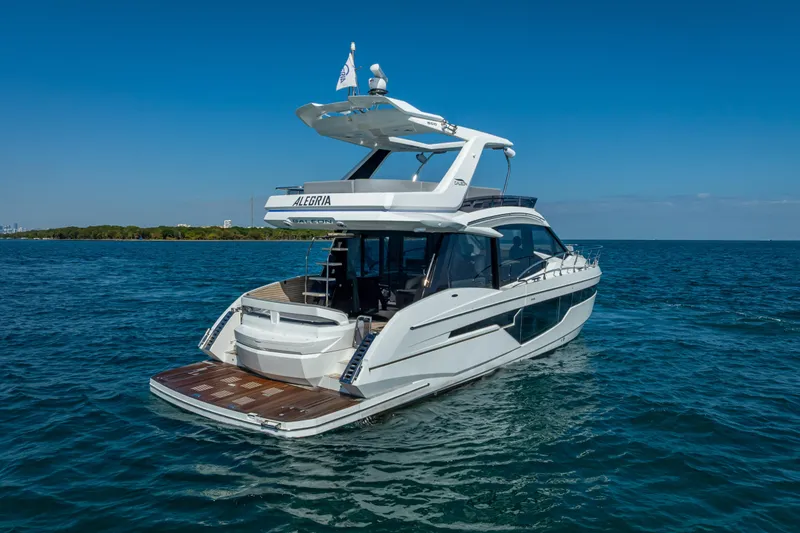 Slide: The Image of 2021 Galeon 500 Fly yacht cruising on open water under clear blue skies. - 15