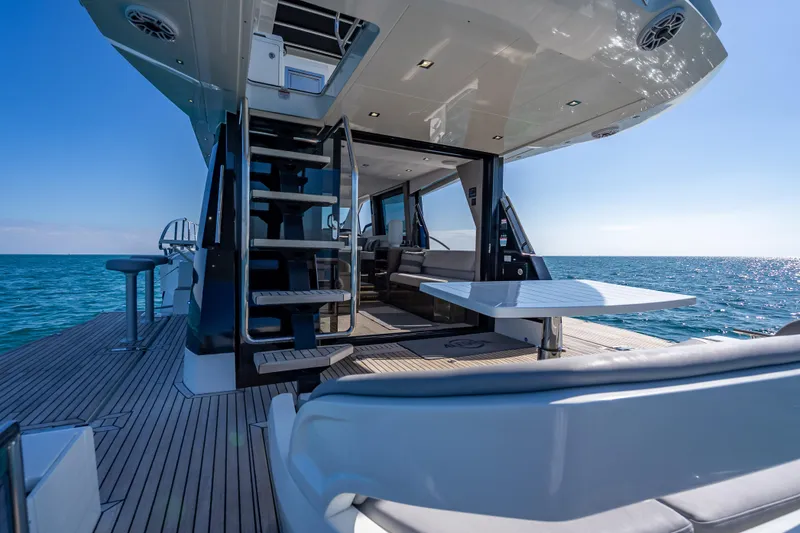 Slide: The Image of Luxury 2021 Galeon 500 Fly yacht deck with ocean view, featuring modern seating and staircase. - 51