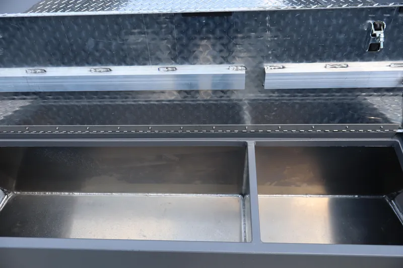 Slide: The Image of Open storage compartments in a 2026 Alumaweld Columbia 21 boat, featuring a diamond plate finish. - 15