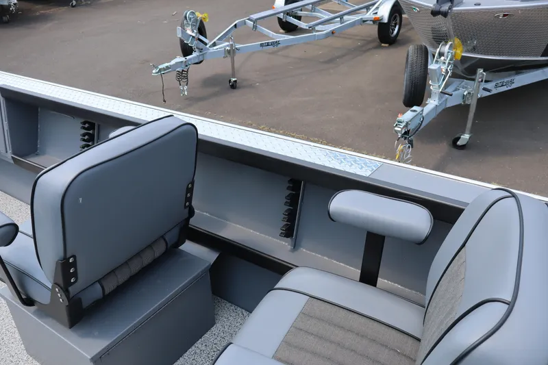 Slide: The Image of Interior of 2026 Alumaweld Columbia 21 boat with gray seating and trailer in background. - 23