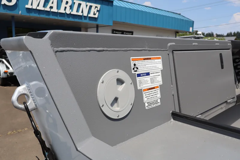 Slide: The Image of 2026 Alumaweld Columbia 21 boat detail with warning labels, displayed at a marine dealership. - 6