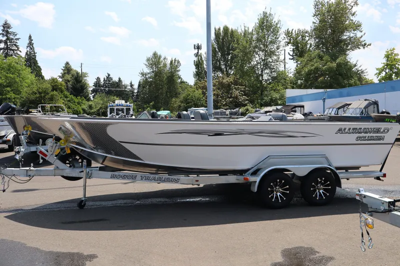 Slide: The Image of 2026 Alumaweld Columbia 21 boat on Rogue Trailers, parked outdoors. - 2