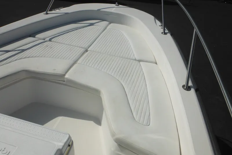 Slide: The Image of 2003 Boston Whaler 220 Dauntless boat interior with cushioned seating and storage compartment. - 36