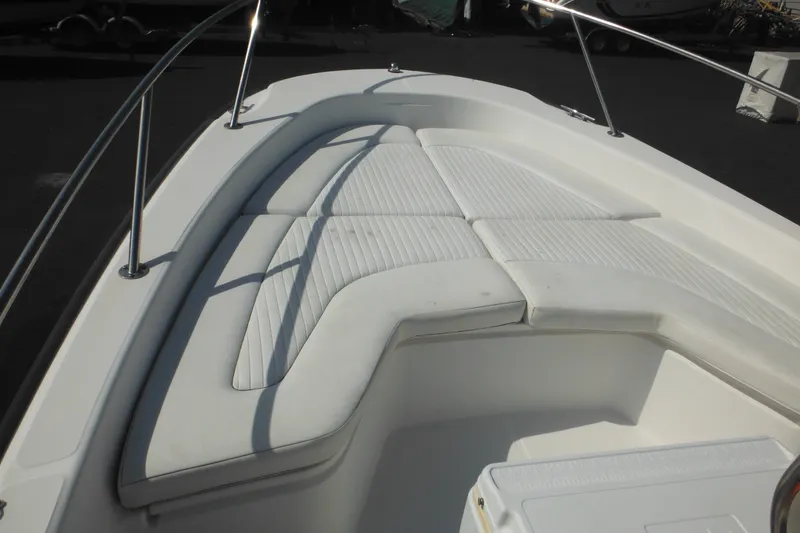 Slide: The Image of 2003 Boston Whaler 220 Dauntless boat with cushioned bow seating area. - 39