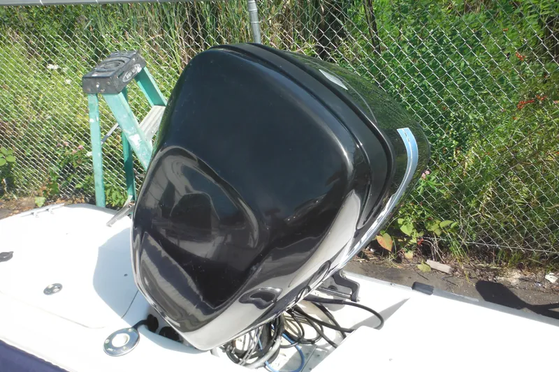 Slide: The Image of 2003 Boston Whaler 220 Dauntless boat engine, black cover, outdoor setting. - 45