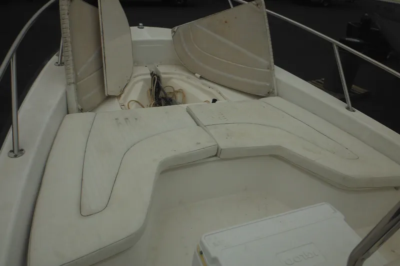 Slide: The Image of 2003 Boston Whaler 220 Dauntless boat interior with open storage compartments and cushioned seating. - 22