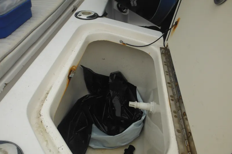 Slide: The Image of Storage compartment on a 2003 Boston Whaler 220 Dauntless boat with black bag inside. - 14