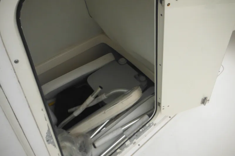 Slide: The Image of Storage compartment inside a 2003 Boston Whaler 220 Dauntless boat, featuring various equipment. - 19