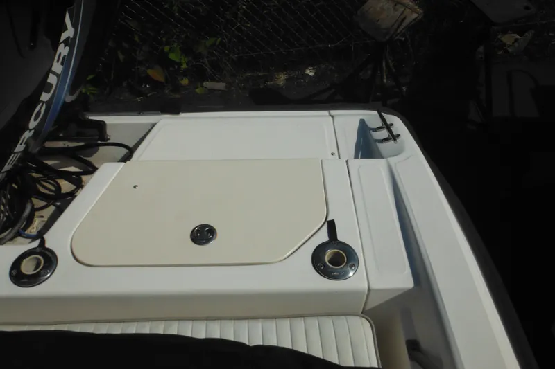 Slide: The Image of 2003 Boston Whaler 220 Dauntless boat deck with storage compartment and Mercury engine. - 44