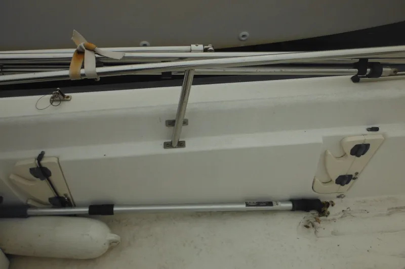Slide: The Image of 2003 Boston Whaler 220 Dauntless boat interior with rod holders and railing. - 32