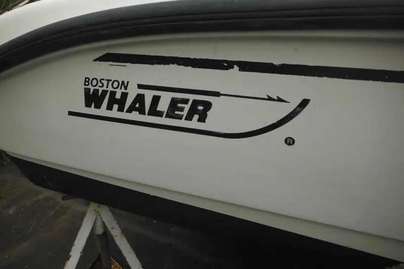 Slide: The Image of 2003 Boston Whaler 220 Dauntless boat logo on hull, close-up view. - 8