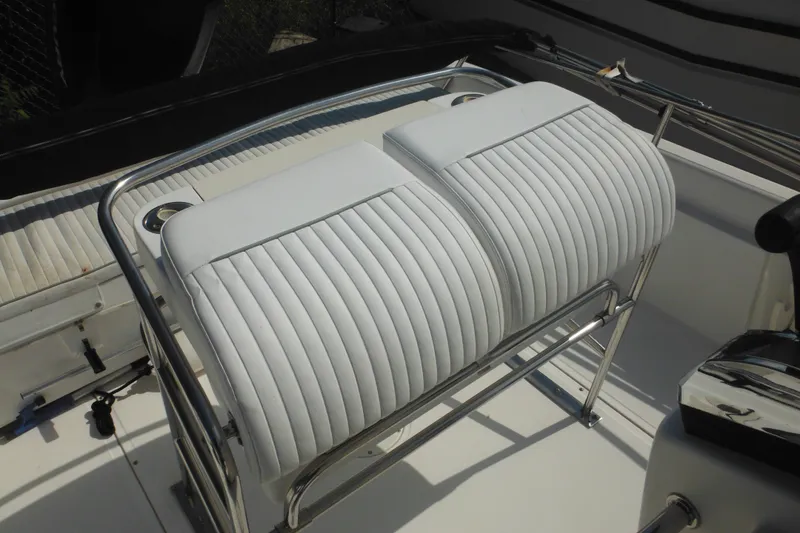 Slide: The Image of 2003 Boston Whaler 220 Dauntless boat seating with white cushioned upholstery and stainless steel frame. - 37