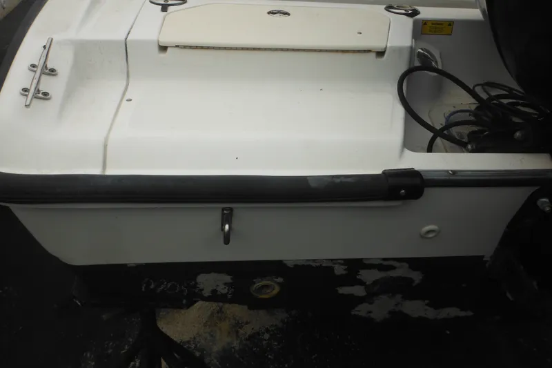 Slide: The Image of 2003 Boston Whaler 220 Dauntless boat stern with storage compartment and railing. - 13