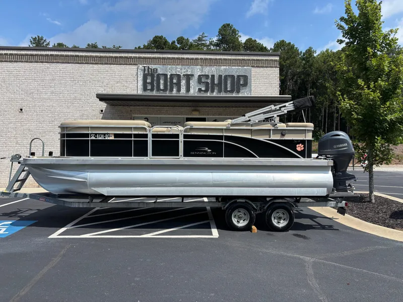 The Image of 2015 Bennington 21 SLX pontoon boat parked in front of a shop. - 1