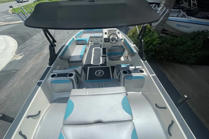 Slide: The Image of 2017 Heyday WT-2 boat interior with seating, steering wheel, and cup holders under a canopy. - 17